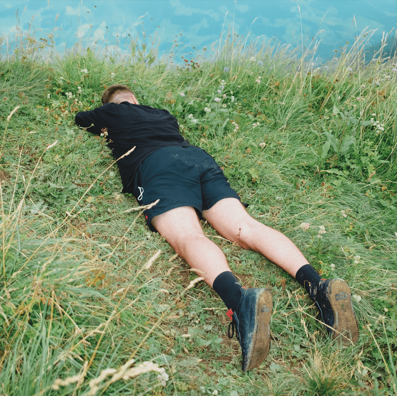 Ein Mann schläft im Gras.