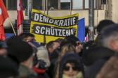 Das Foto zeigt eine Demonstration, auf der ein Banner mit der Aufschrift "Demokratie schützen" hochgehalten wird Wehrhafte Demokratie und ihre Eliten: Wie Karl Mannheim die Freiheit planen wollte